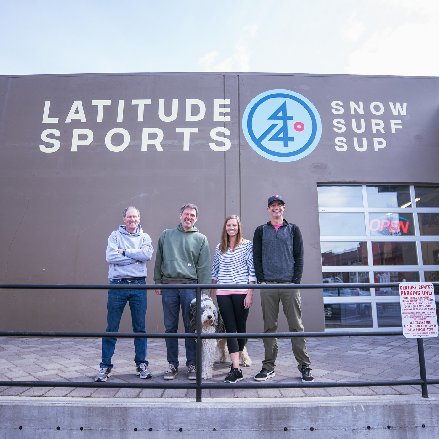 Stand on Liquid and Latitude 44 Sports team photo in front of paddle board and used gear consignment shop