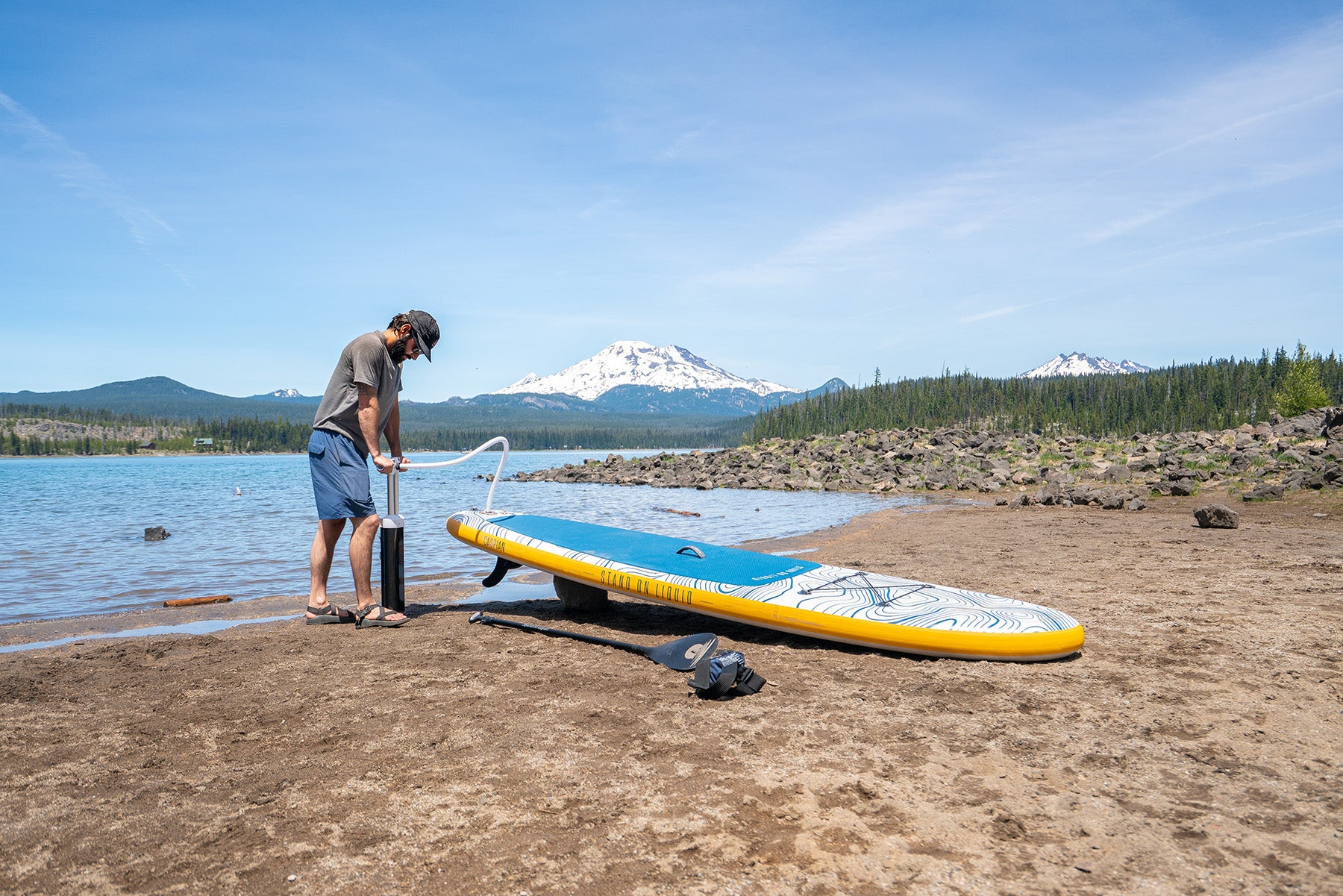 Man inflating hudson inflatable stand up paddleboard by Stand on Liquid at Sparks Lake Oregon