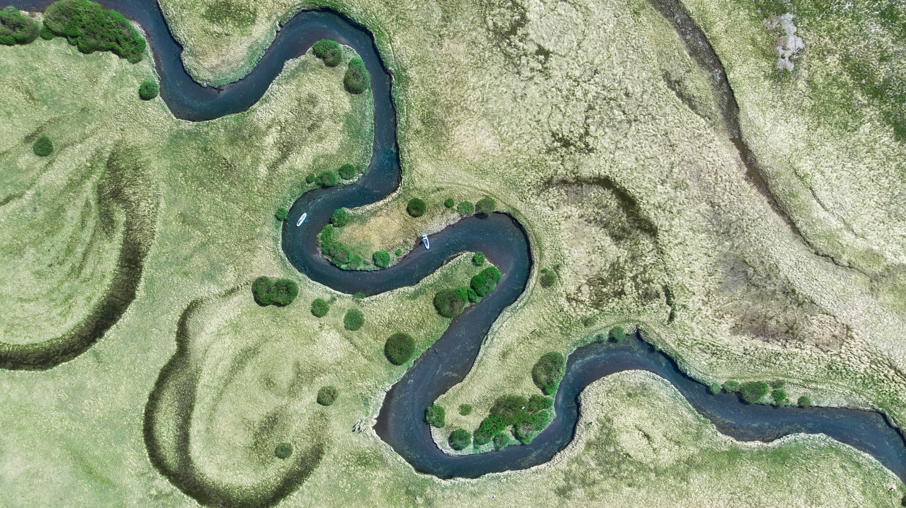 Winding creek with paddleboarder paddling at Sparks lake oregon