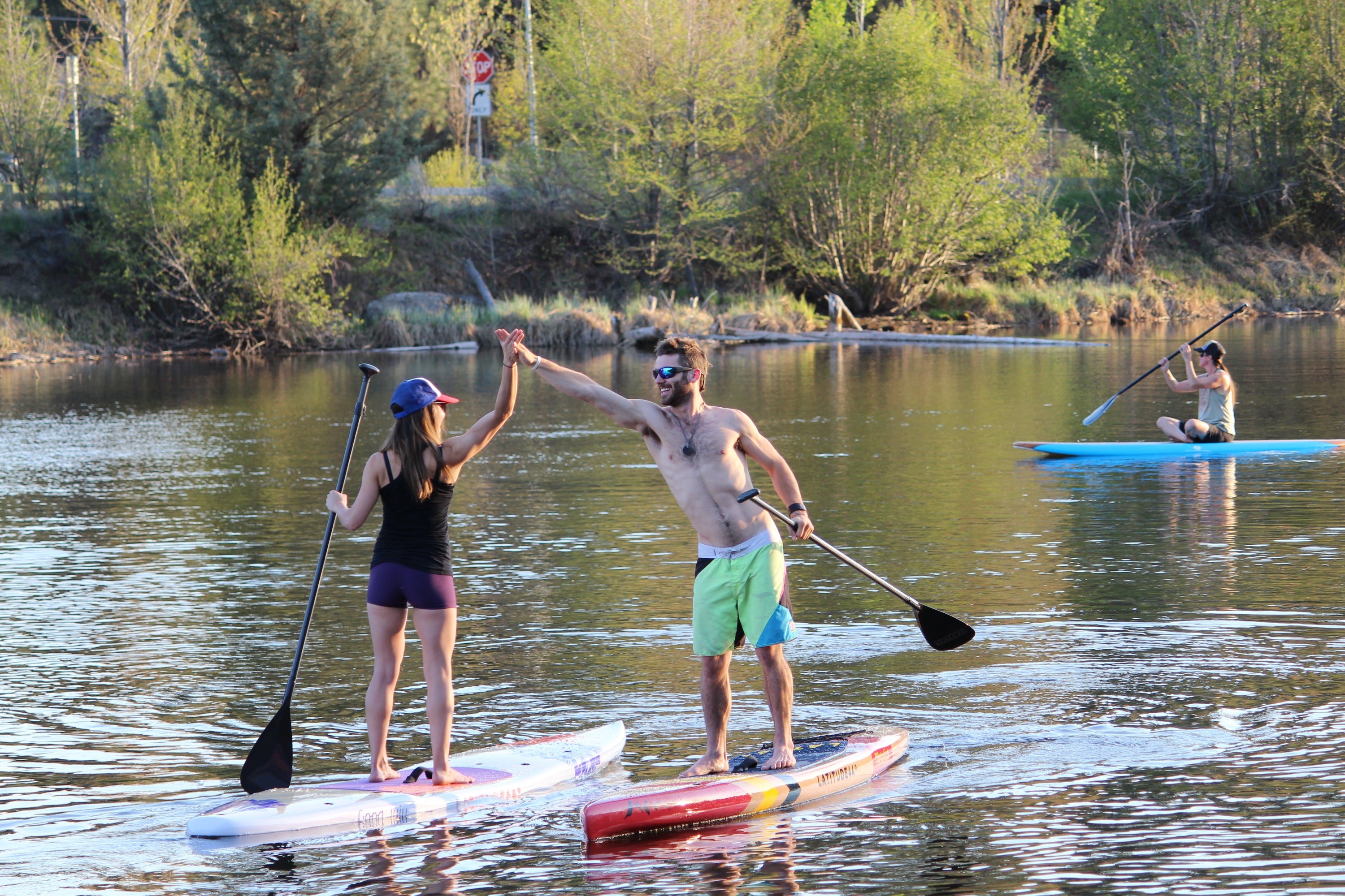 High five on stand up paddleboards by Stand on Liquid on Deschutes River